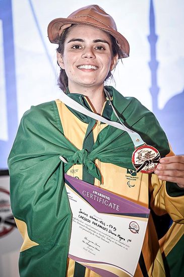 Silvana lutando, com a bandeira do Brasil e com a medalha no peito